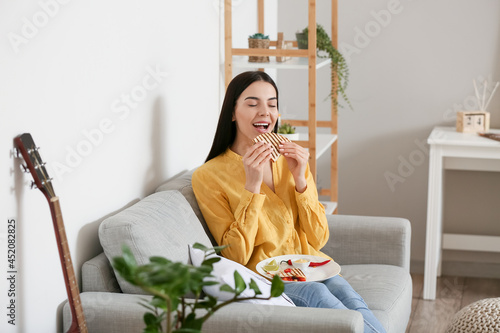 Beautiful young woman eatin...