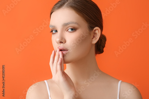 Beautiful young woman with dyed eyebrows on color background