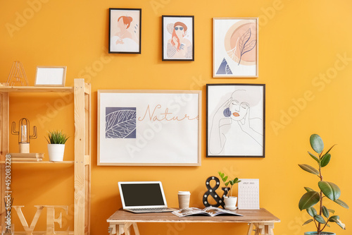Interior of stylish room with modern workplace and pictures