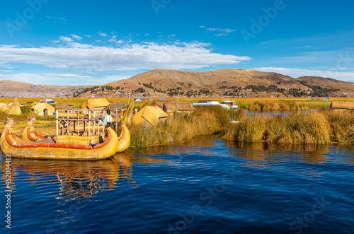 Uros floating islands with totora reed boat, Titicaca Lake, Peru.