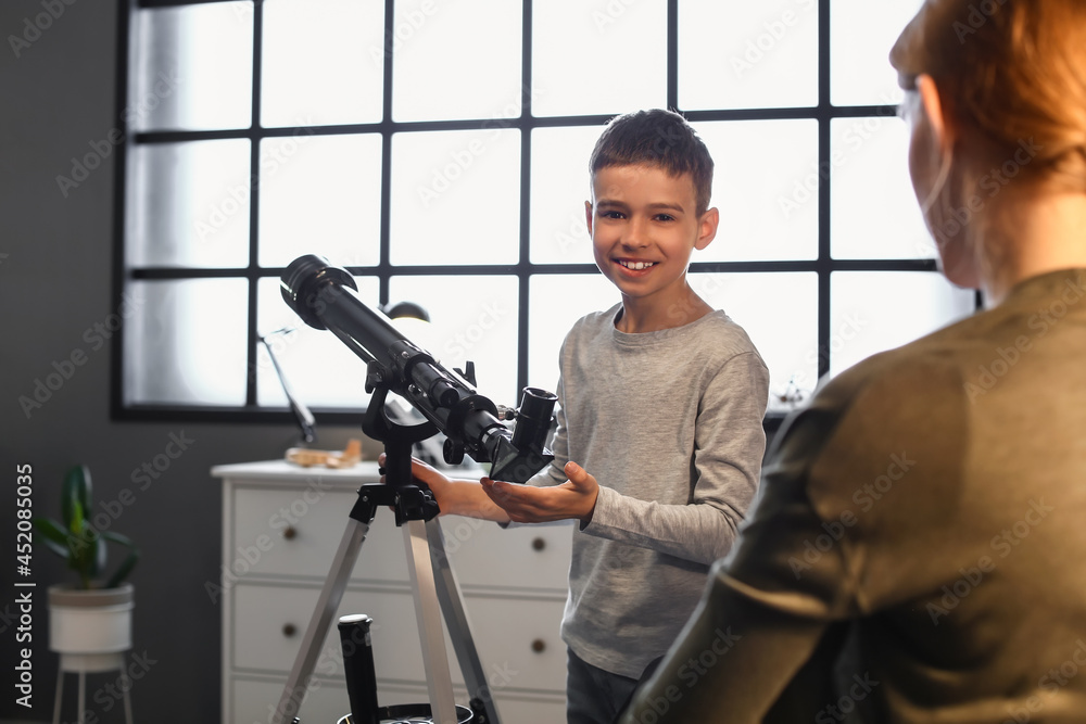Little boy and his mother with telescope looking at stars in evening Little boy and his mother with telescope looking at stars in evening