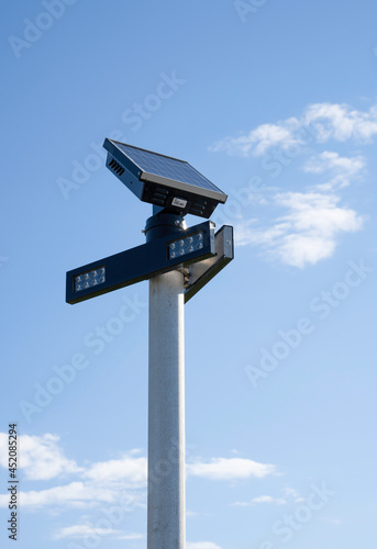 A solar charging LED warning light at a crosswalk