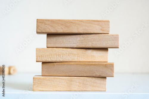 A pile of five wooden blocks on the soft white background.