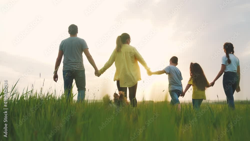 people in the park. happy family a silhouette walk in field. mom dad and daughters, son walk holding hands in park. happy family kid dream concept fun. parents and children walking back silhouette people in the park. happy family a silhouette walk in field. mom dad and daughters, son walk holding hands in park. happy family kid dream concept fun. parents and children walking back silhouette