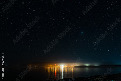 night view to small town at Mount Waddington many stars on dark sky. © olegmayorov