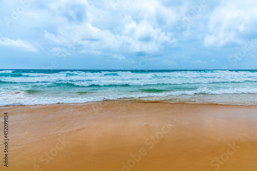 Landscape of sea beach sand and cloudy blue sky with sunny in windy day at Phuket sea Thailand.