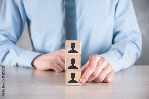 Businessman hold and put wooden cube block shape with user icon on grey table. Space for text. Internet icons interface foreground. global network media concept,contact on virtual screens ,copy space