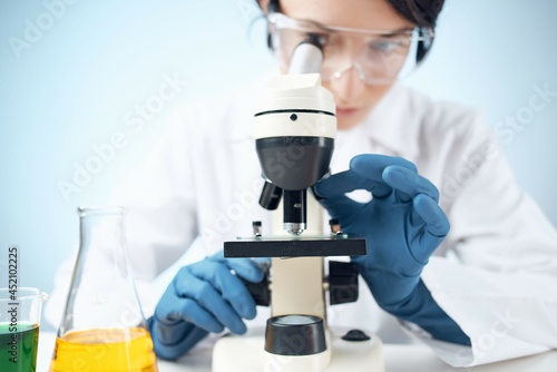laboratory assistant looking through a microscope science research technology experiment