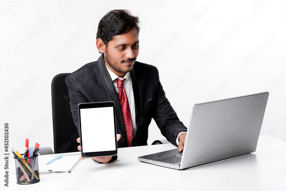 technology concept : Young indian businessman showing tablet scr