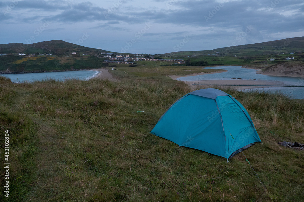 Night scene. Blue tent on a grass. Barleycove beach in the background