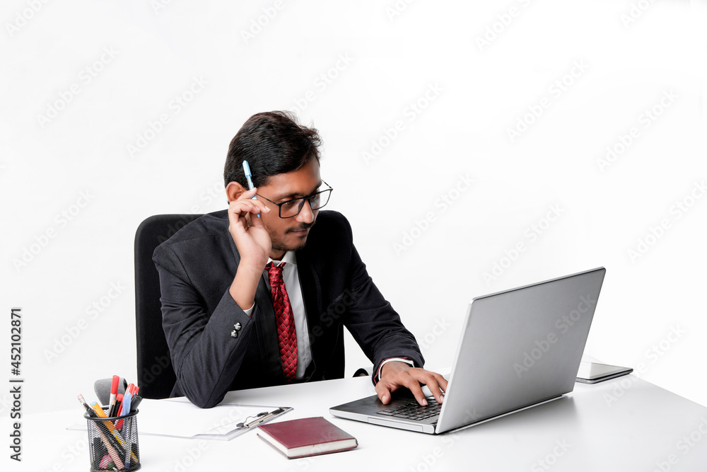 Young indian man in suit and working on laptop at office Young indian man in suit and working on laptop at office