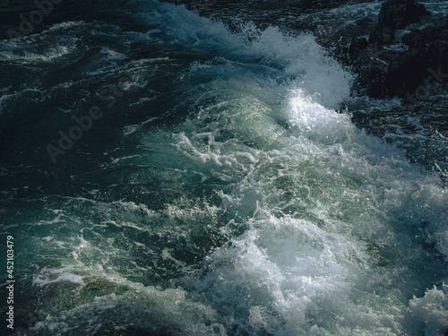 Tide wave on the rocky beach.