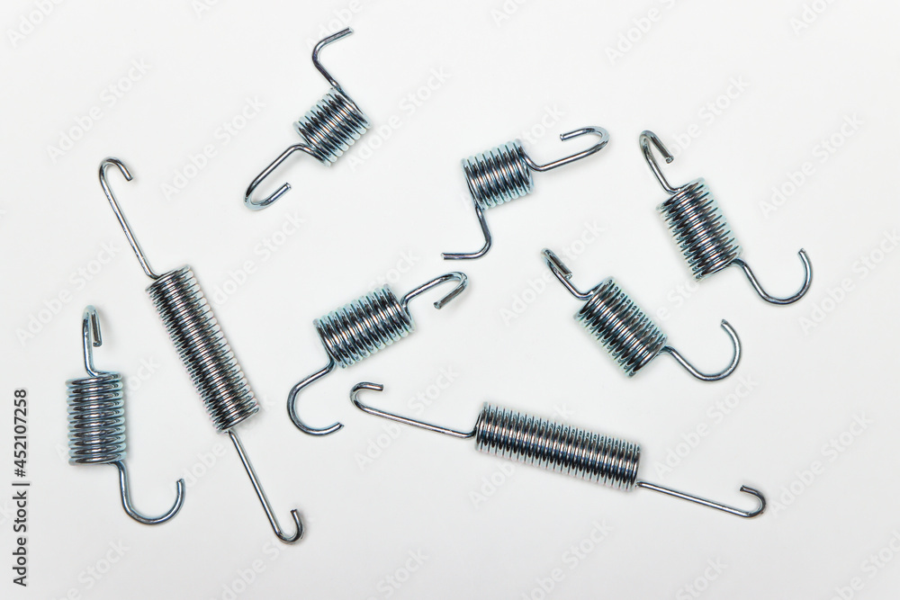 My metal springs on the table, machine repair parts. A set of spare parts for servicing vehicle calipers. Details on white background, copy space available. My metal springs on the table, machine repair parts. A set of spare parts for servicing vehicle calipers. Details on white background, copy space available.