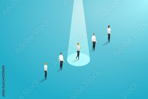 Businesswoman standing in a striking light unlike other employees.