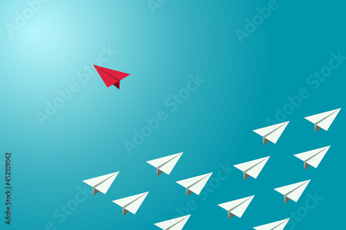 Red paper plane changed direction from a group of white planes.