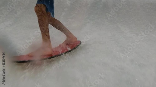 Footage of legs of male surfer with surfboard  . Close up of surfer legs on surfboard riding inside flow house . Surfing ocean lifestyle, extreme sports, slow motion photo