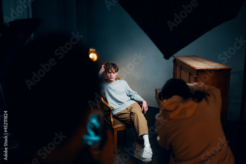 guy sitting on a chair next to the piano posing photo