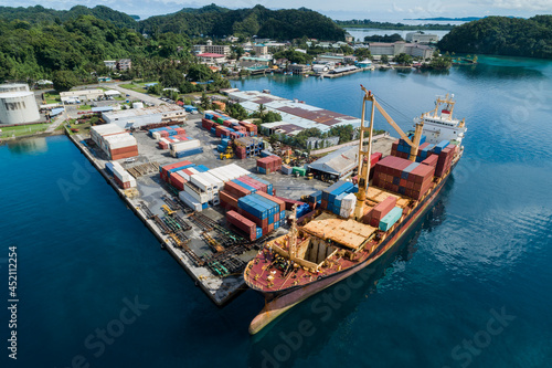 Container ship unloads cargo at dock in Micronesia