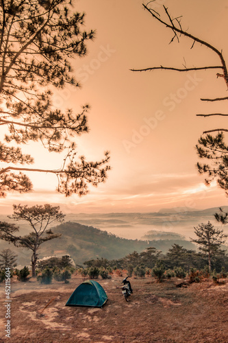Da Lat, Vietnam. Tourist camping in mountains. Cold early morning with fog over mountains and city photo
