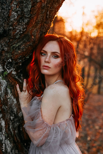 Portrait of young redhead woman in autumn yellow park