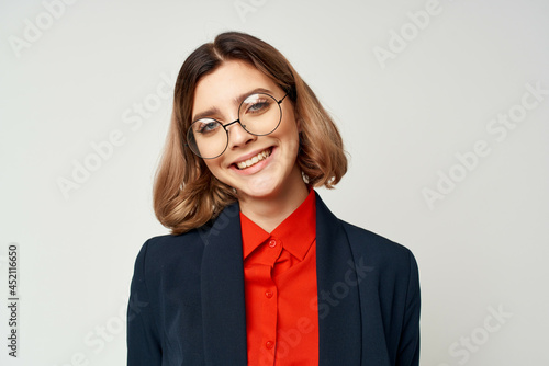 cheerful business woman in a suit gesturing with her hands work manager light background