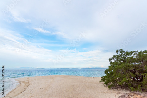 Beach sand, sea and blue sky with clouds. Nature in twilight period which including of sunrise over the sea and the nice beach. Summer beach with blue water and purple sky at the sunset. 