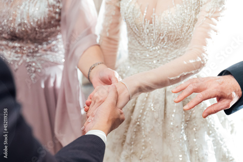 In the wedding ceremony, the parents entrust their daughter's hand to the son-in-law's hand close-up