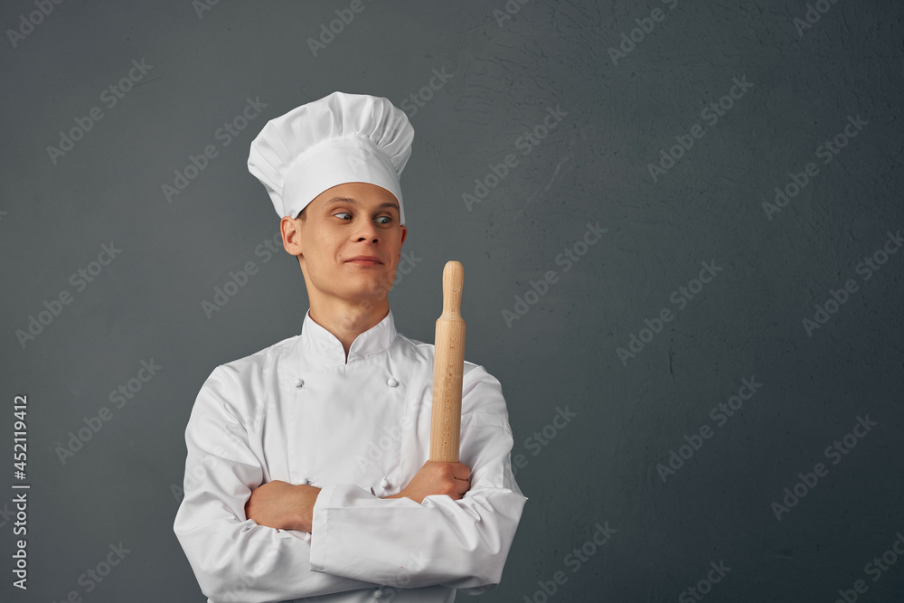 Cheerful chef in uniform kitchen items in the hands of a professional restaurant Cheerful chef in uniform kitchen items in the hands of a professional restaurant