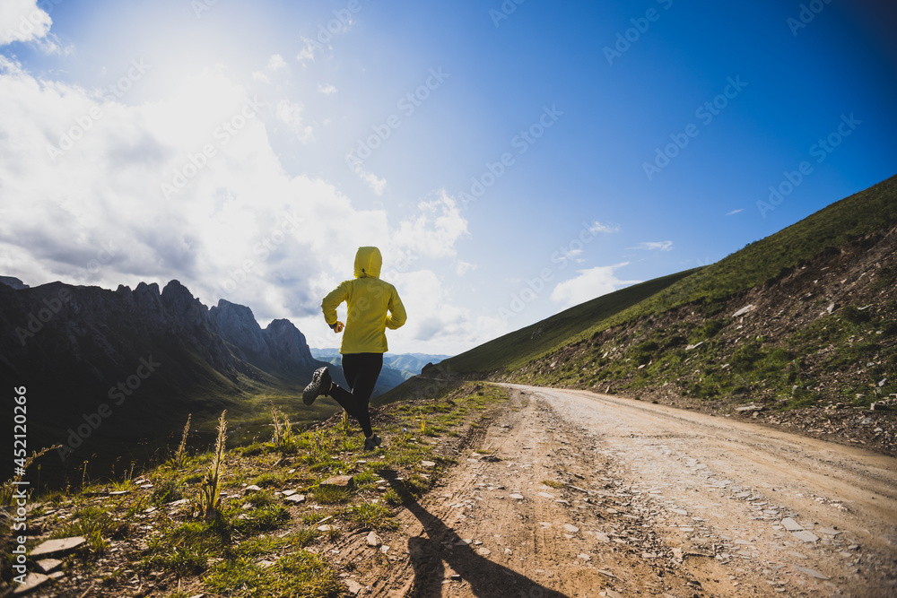 Obraz premium Woman runner running at mountain top