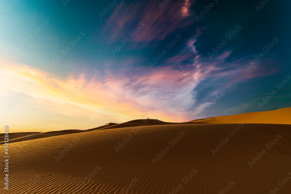 (Selective focus) Stunning sunset over some sand dunes of the Merzouga desert in Morocco. Merzouga is a small village in southeastern Morocco. Natural background with copy space.