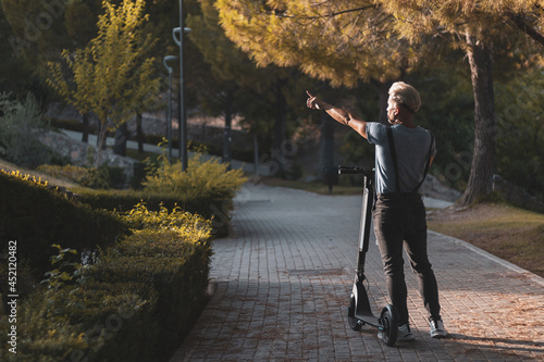 A gay boy stops his scooter to point out where he wants to go to clear his anxiety. lgtbi