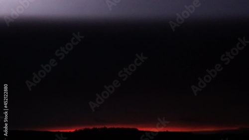 video ralentie de la foudre spider qui fait une boucle dans le ciel avant un orage dans un ciel de couleur magenta avec dans le fond un splendide coucher de soleil rouge