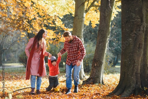 happy young family spending time outdoor in the autumn park