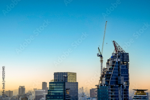 Hight rising crane working on building with sunset twilight sky background