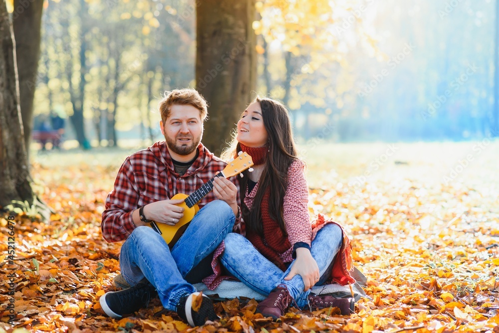 Couple in the autumn park.Smiling man and woman outside. Couple in the autumn park.Smiling man and woman outside.