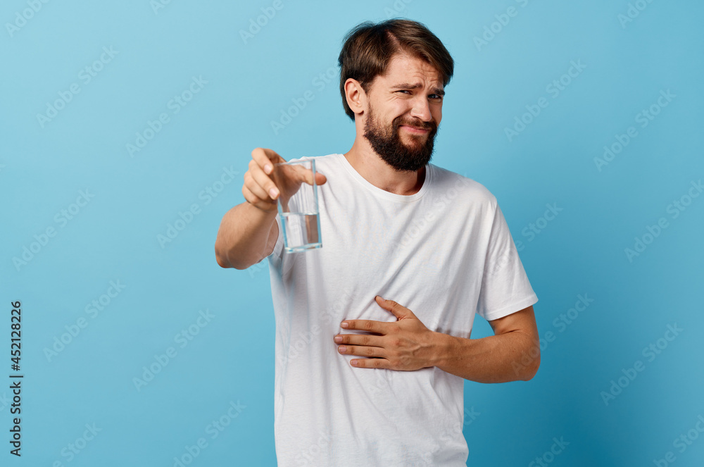 pretty man drinking water blue background pretty man drinking water blue background