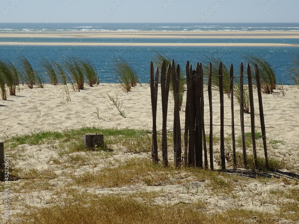 sand dunes and sea with old wooden fence west france