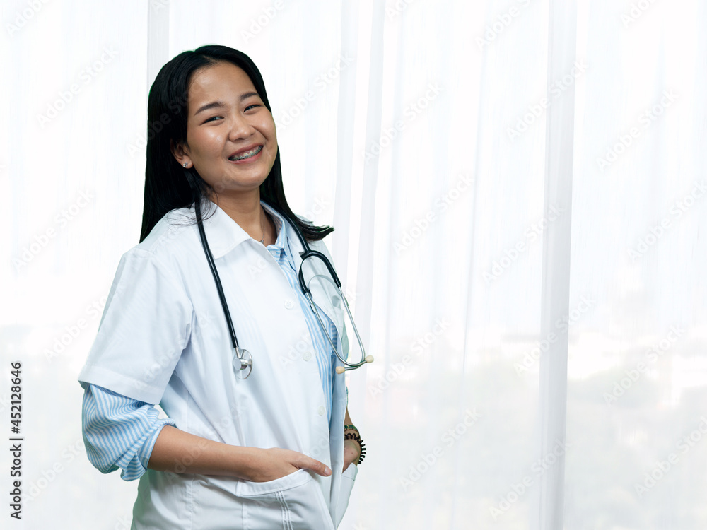 Young female Asian happiness doctor in uniform with stethoscope standing in hospital room Young female Asian happiness doctor in uniform with stethoscope standing in hospital room