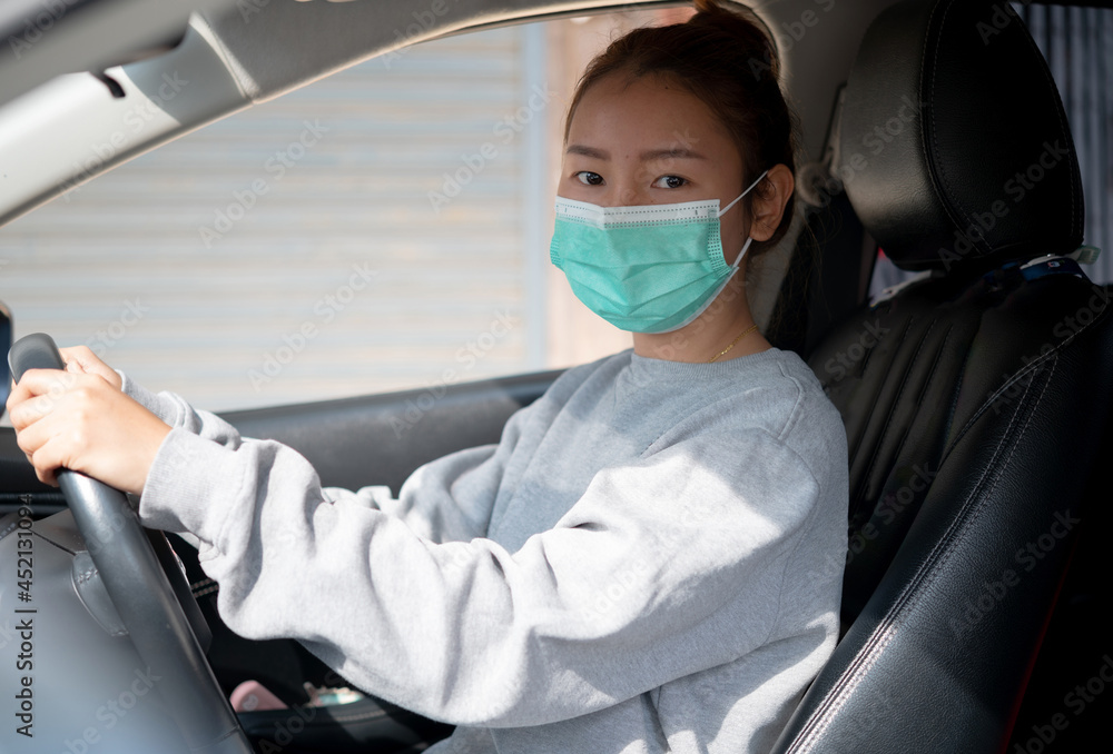 Beautiful young girl in a mask sitting in a car, car insurance Beautiful young girl in a mask sitting in a car, car insurance