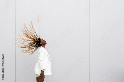 Young african american woman tossing long braided hair back. Copy space. photo