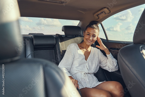 Woman sitting on rear seat of automobile