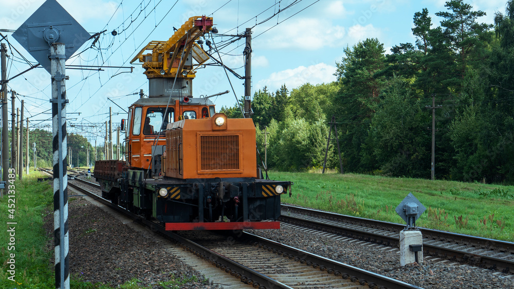 Special train with a landing crane for service and repair of electrical networks on the railway. Heavy machinery repairs rail lines. Railroad concept.