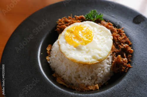 Menu of bluron duck on the wooden table. bluron duck is slow-cooked pulled duck, marinated herbs, steamed rice, sunny side-up eggs. top view photo