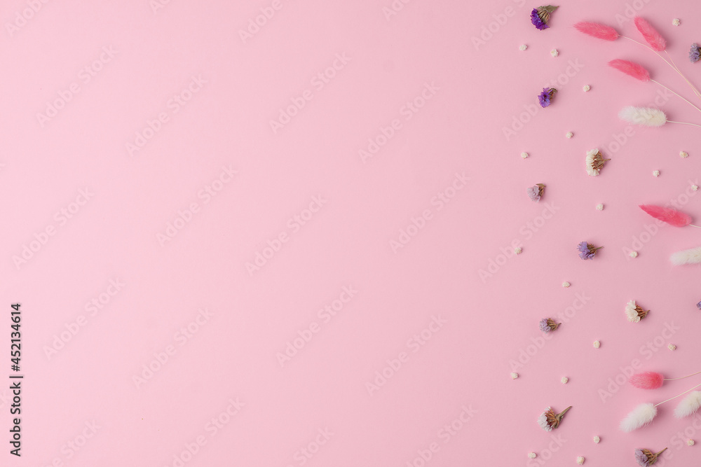 Cosmetic background with flowers on pink. Flat lay, copy space