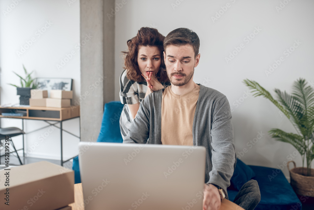 Two young coworkers reading an email message Two young coworkers reading an email message