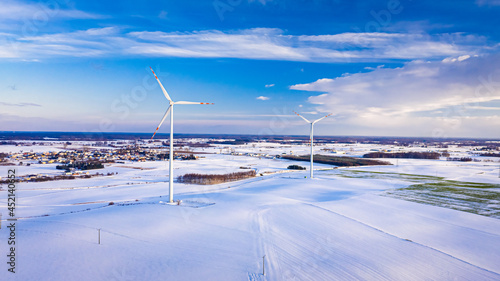 Wind turbine and snowy field at sunrise in winter © shaiith