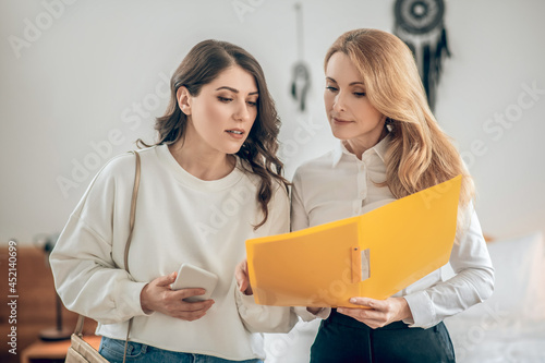 Young woman talking with a real estate agent about renting an apartment and looking involved