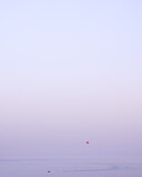 Minimalist view of a parasailer and a boat on the Becici sea, Montenegro, with colorful purple sky and a lot of copy space