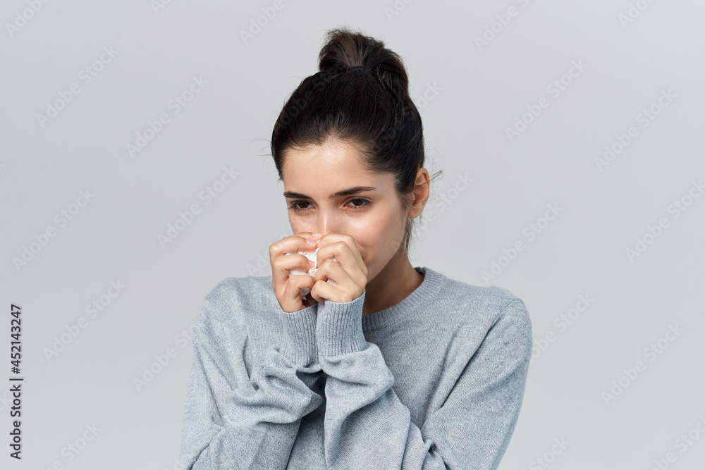 woman in gray sweater wipes her face with a handkerchief health problems woman in gray sweater wipes her face with a handkerchief health problems