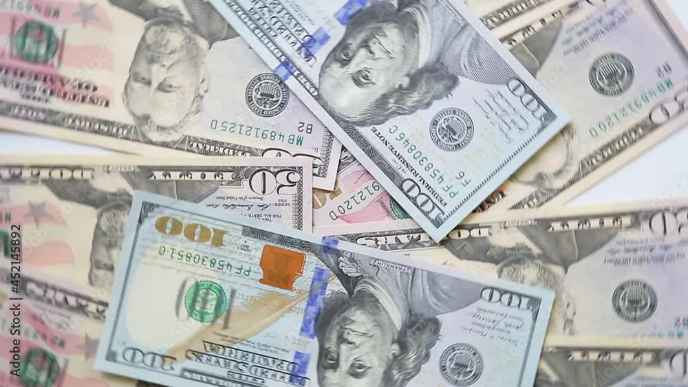 Dollar bills fifty and one hundred spread out on the table rotate in a circle. Close-up Dollar bills fifty and one hundred spread out on the table rotate in a circle. Close-up